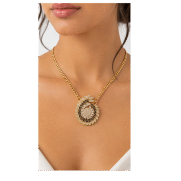 Gold chain necklace with a circular pendant featuring a black geometric center and surrounding diamond accents on a model's décolletage, close-up portrait.
